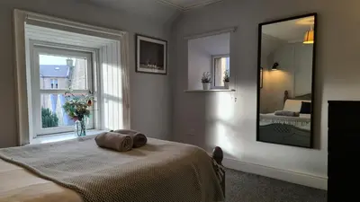 a bedroom with a bed and a large window at One Oban in Oban