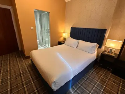 a bedroom with a large bed with white sheets and pillows at The Valentine - Townhouse Hotel - Adults Only in Edinburgh