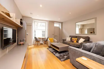 a living room with a couch and a table at JOIVY Splendid Flat near Edinburgh Castle in Edinburgh