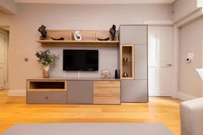 a living room with a entertainment center with a tv at JOIVY Splendid Flat near Edinburgh Castle in Edinburgh