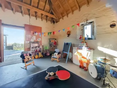 a room with a drum set and toys in it at Old Stable Cottage in Uplawmoor