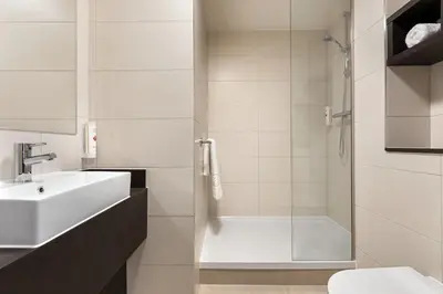 a bathroom with a shower and a sink and a toilet at Ramada East Kilbride in East Kilbride