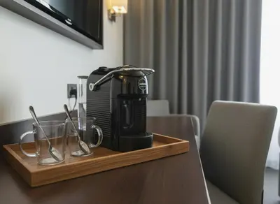 a coffee maker on a wooden tray on a table at Ramada East Kilbride in East Kilbride