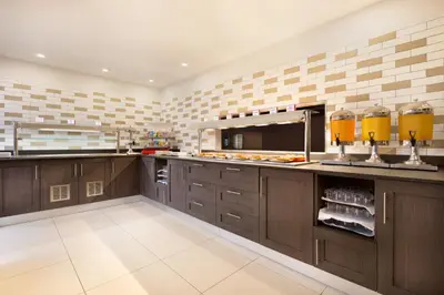 a large kitchen with wooden cabinets and a counter top at Ramada East Kilbride in East Kilbride
