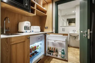 a small kitchen with an open refrigerator with drinks at Bonnie Hotel - Smart Boutique ApartHotel - Haymarket Edinburgh in Edinburgh