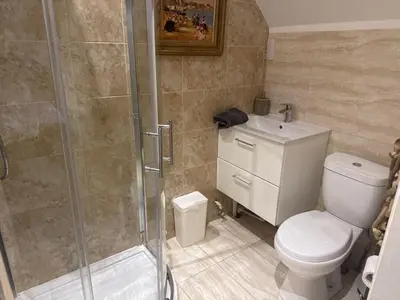a bathroom with a shower and a toilet and a sink at The West Highland Way Hotel and Retreat Accommodation in Glasgow