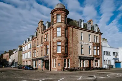 a large brick building with a tower on a street at The Royal Hotel Campbeltown in Campbeltown