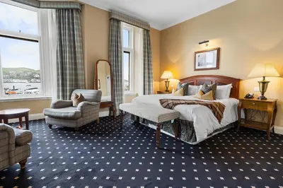a hotel room with a bed and a chair at The Royal Hotel Campbeltown in Campbeltown