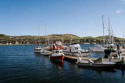 a group of boats are docked in a harbor at The Royal Hotel Campbeltown in Campbeltown