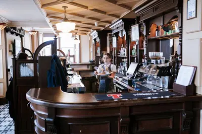 a man standing behind the counter of a bar at The Royal Hotel Campbeltown in Campbeltown