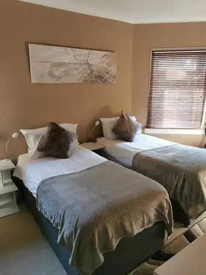 a bedroom with two beds and a window at Arrochoile in Balmaha