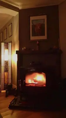 a fireplace in a living room with a fire place at Arrochoile in Balmaha