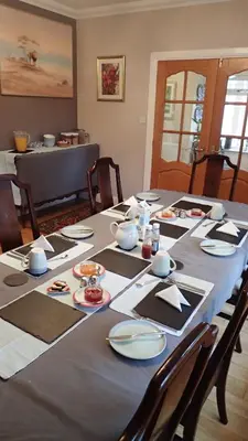 a dining room table with plates and dishes on it at Arrochoile in Balmaha