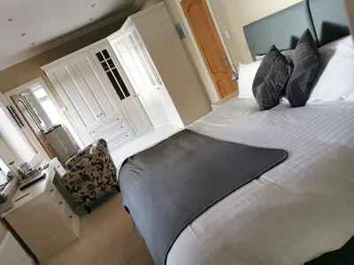 a bedroom with a large white bed with pillows at Arrochoile in Balmaha