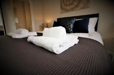 a bed with white towels on top of it at Signature - Morrison House in Glasgow