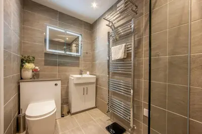 a bathroom with a toilet and a glass shower at Mandarin Premier Apartments D 2 Bed Apt 1st Floor in Oban