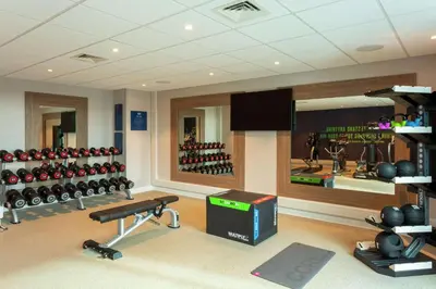 a fitness room with a gym with a lot of equipment at Hampton By Hilton Hamilton Park in Hamilton