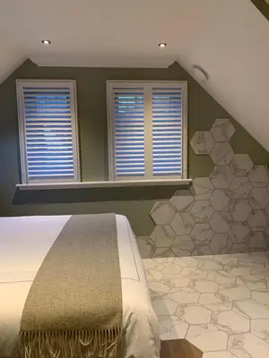 a bedroom with a bed and two windows at Bagpipers Luxury Hideaway Glencoe Ballachulish Highlands Near Fort William in Glencoe