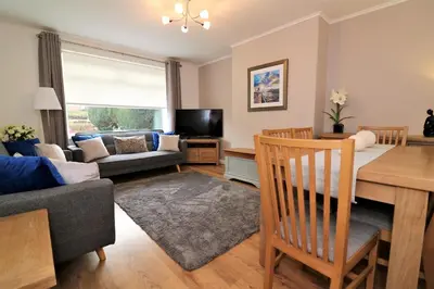 a living room with a table and a dining room at Signature - Gordon House in Glasgow