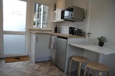 a small kitchen with a counter and two stools at The Wee Bank House in Oban