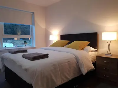 a bedroom with a large bed and a window at 1 Royal View Apartments in Stirling