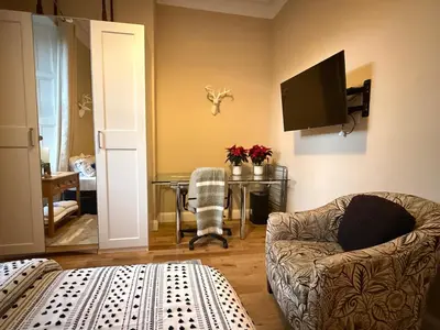 a living room with a couch and a table with a television at Murrayfield Spacious 2-bedroom apartment in Edinburgh