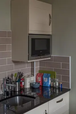a kitchen counter with a sink and a microwave at Murrayfield Spacious 2-bedroom apartment in Edinburgh