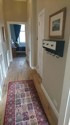 a hallway of a home with a rug on the floor at Murrayfield Spacious 2-bedroom apartment in Edinburgh