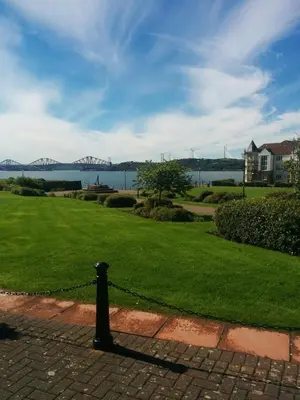 a black pole on a brick walkway with a view of the water at Boutique Coastal appt nr Edinburgh in Saint Davids