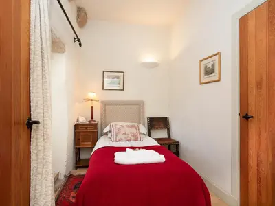 a bedroom with a red bed with two towels on it at Braidwood Castle - Uk10672 in Braidwood