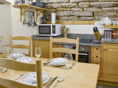 a kitchen with a table with plates and wine glasses at Braidwood Castle - Uk10672 in Braidwood