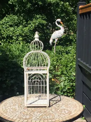a bird standing next to a bird cage at Otter Lodge Auchterarder in Auchterarder