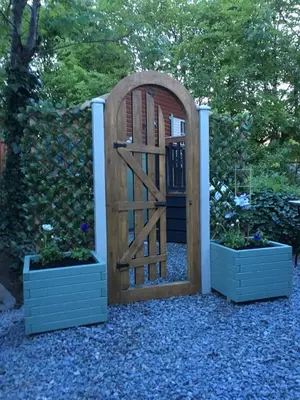a wooden gate with two potted plants next to it at Otter Lodge Auchterarder in Auchterarder
