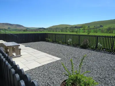 a patio with a bench and a fence at Blueacres in Skirling
