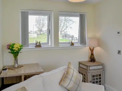 a living room with two windows and a couch at Blueacres in Skirling