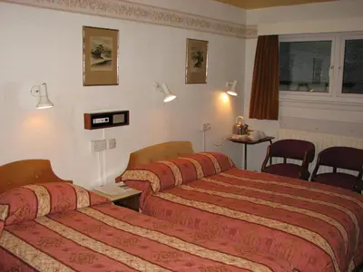 a hotel room with two beds and a table and chairs at Lancaster Hotel in Oban