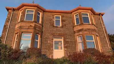a large brick building with windows on top of it at Dunrigh Guest House in Oban