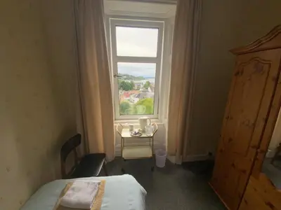 a room with a bed and a window and a table at Dunrigh Guest House in Oban