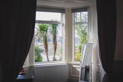 a window with a palm tree in a room at Heatherfield House in Oban