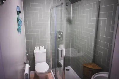 a bathroom with a toilet and a glass shower at Heatherfield House in Oban