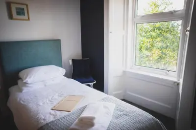 a bedroom with a bed with a book on it at Heatherfield House in Oban