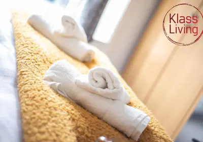 a pile of towels sitting on top of a bed at Albion Apartment by Klass Living Coatbridge in Coatbridge