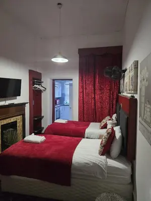 two beds in a hotel room with a fireplace at The Residence - NO 57 in Edinburgh