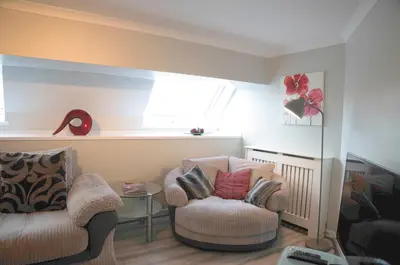 a living room with two chairs and a window at The Stables - Fabulous stylish flat in Merchant City & Free Secure Parking in Glasgow