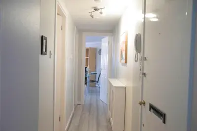 a hallway with white walls and wooden floors and a room at The Stables - Fabulous stylish flat in Merchant City & Free Secure Parking in Glasgow