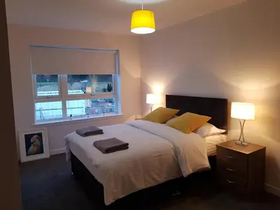 a bedroom with a large bed with two towels on it at 9 Royal View Apartment in Stirling