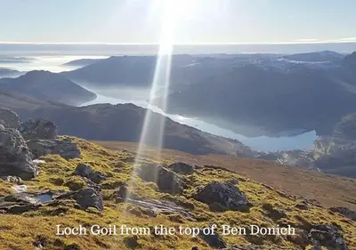 a view of the top of a mountain with the sun shining at Byron Cottage overlooking Loch Goil in Lochgoilhead