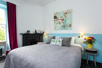 a bedroom with a bed with a fireplace and a painting at New Town Guest House (Adults Only) in Edinburgh