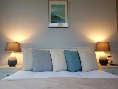 a bedroom with a white bed with two lamps at Kames Hotel in Tighnabruaich