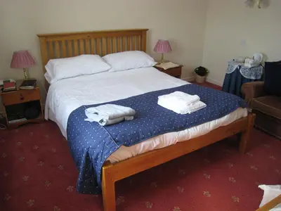 a bedroom with a bed with two towels on it at Herdshill Guest House in Wishaw